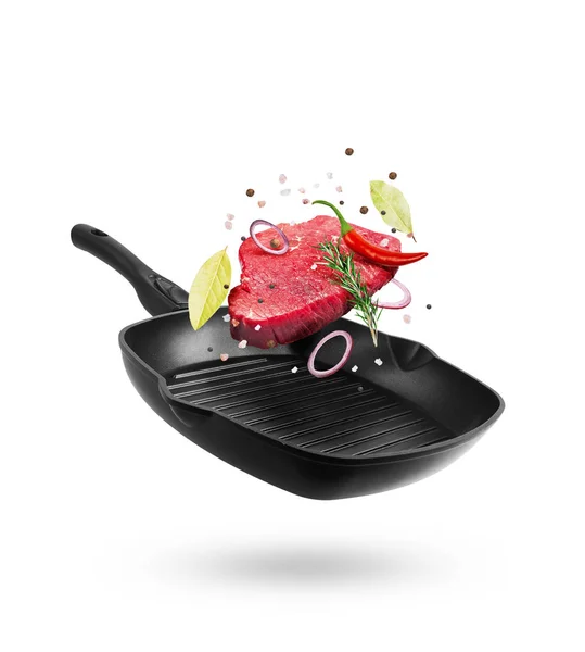 Beef meat flying from a pan with spice and pepper — Stock Photo, Image