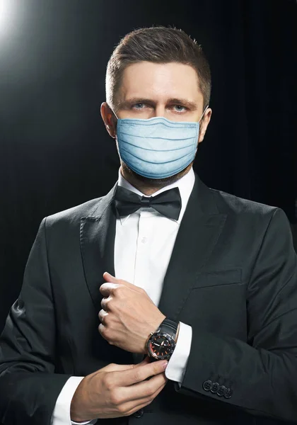 Man in black suite in a protection mask, for a prevention from covid-19 virus