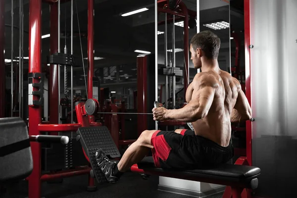 运动员肌肉健美训练模拟器在健身房上回来 — 图库照片