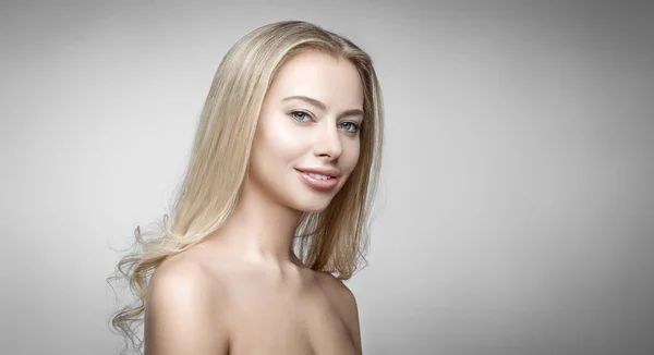 Attraktiva blonda leende kvinna stående på grå bakgrund — Stockfoto