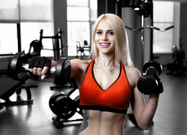 Spor salonunda spor kıyafetleri giymiş güzel seksi bir kadının portresi.