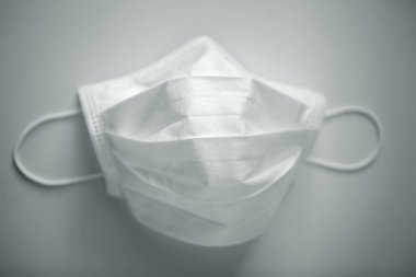 Gri arka planda gölgeli koruyucu tıbbi maske.