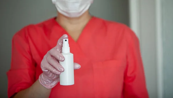 Eldivenli ve maskeli kadın doktor, elinde dezenfektan spreyi tutuyor.. — Stok fotoğraf