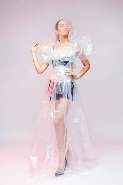 Дівчинка одягає плаття, зроблене з пластмасового кіно. Кові19 Моданий портрет. — стокове фото