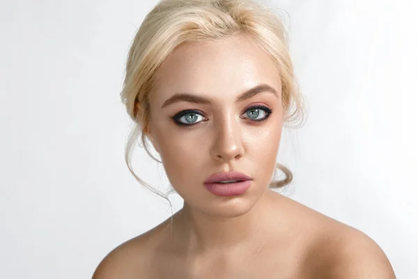 Schöne blonde Frau mit Make-up auf hellgrauem Hintergrund. — Stockfoto