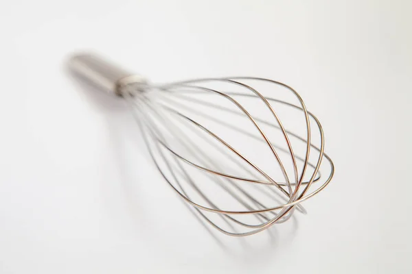 Metal whisk pro bičování na šedém pozadí. — Stock fotografie