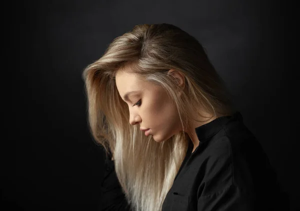 Dramatic studio portrait of beautiful young woman on dark background. — Stock Photo, Image