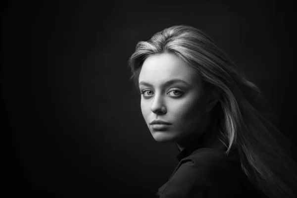 Dramatic studio portrait of beautiful young woman on dark background. — Stock Photo, Image