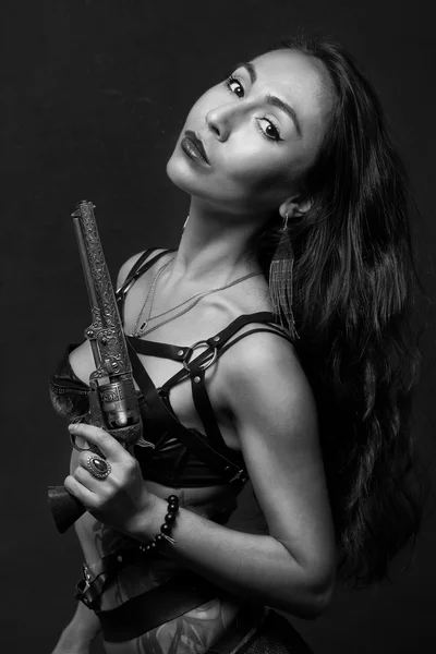 Sexy Mädchen in schwarzer Dessous und Schwertgürtel auf grauem Hintergrund. hält den alten Revolver in der Hand — Stockfoto
