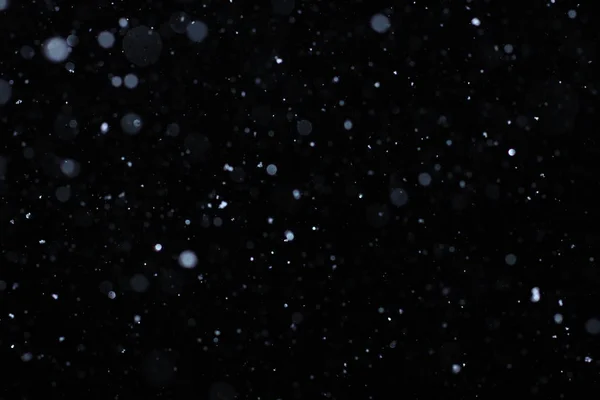 Neve caindo real em um fundo preto para uso como uma camada de textura em seu projeto. Adicionar como "Iluminar" camada no Photoshop para adicionar queda de neve para qualquer imagem. Ajustar a opacidade ao paladar . — Fotografia de Stock