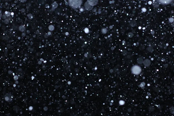 Neve caindo real em um fundo preto para uso como uma camada de textura em seu projeto. Adicionar como "Iluminar" camada no Photoshop para adicionar queda de neve para qualquer imagem. Ajustar a opacidade ao paladar . — Fotografia de Stock