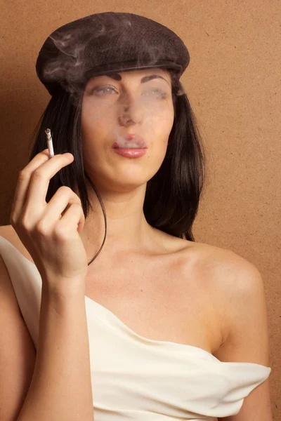 Girl in the French style blowing smoke — Stock Photo, Image