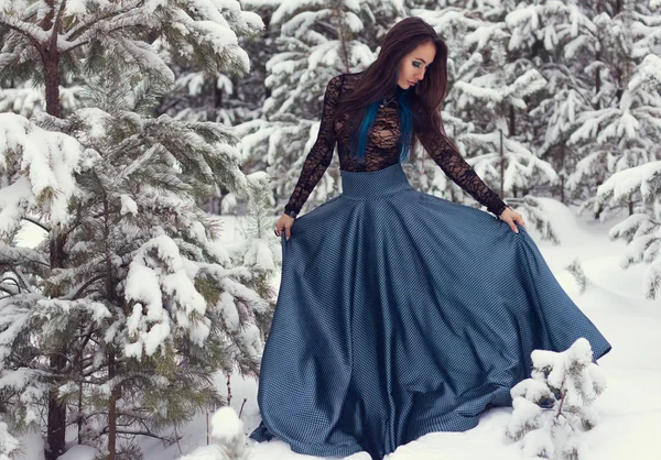 Mooie donkere harige meisje in blauwe jurk verloren in het winter magic forest. — Stockfoto