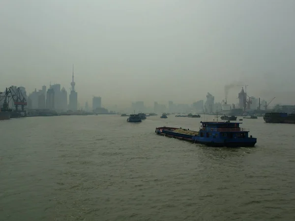 Shanghai, China 28 Aug.: Druk de Huangpu rivier bij schemering smog. Uitzicht vanaf de boord van het vaartuig. Stadsgezicht op de achtergrond. Shanghai, China, 28 augustus 2006 — Stockfoto