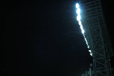 Karanlık gece gökyüzü arka plan karşı kar yağışı sırasında Stadyumu Spot Işık kulesi 