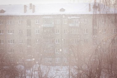 Kış kentsel arka plan bulanık kar taneleri ile.