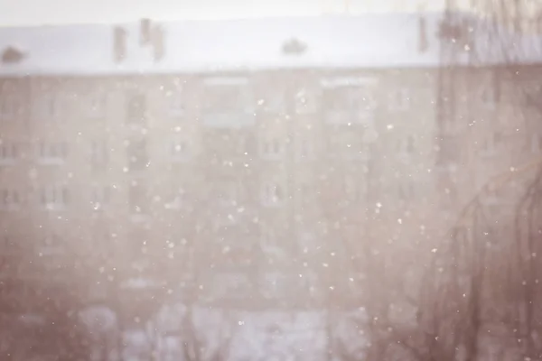 Vinter urbanblurred bakgrund med snöflingor. — Stockfoto