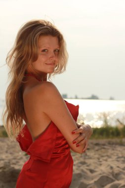 Plaj yaz aylarında neşeli rahatlatıcı zevk güzel Kırmızı elbiseli mutlu kadın. 