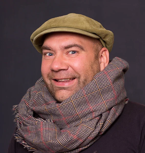 Artista ridículo con gorra y bufanda sobre fondo oscuro . — Foto de Stock