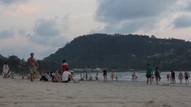 Phuket, Tayland - 14 Şubat 2017: Patong Beach gün batımı. Yürüyüş ve Yüzme bir ünlü Phuket üzerinde turist kalabalığından Patong beach.  