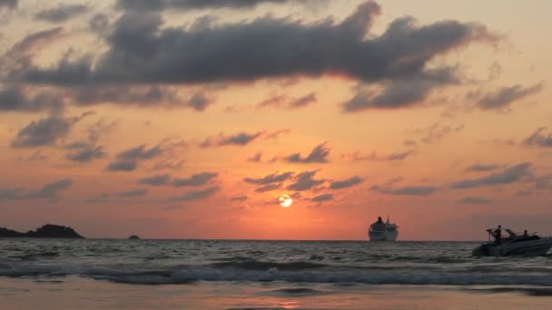 PHUKET, THAILAND - MARCH 14, 2017: Sunset on Patong beach. Crowds of tourists walking and swimming on one of the famous Phuket beach Patong. — Stock Video