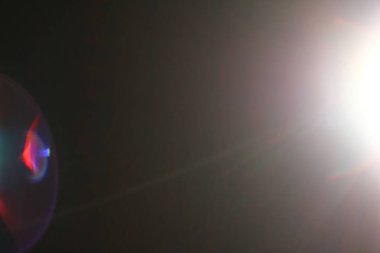 Arka plan - ışığı yanıp söner ve bokeh. Güneş ışınları. Gölgeler. Mercek parlaması siyah bir arka plan olarak bir doku katmanının, projenizde kullanmak için. Işık yanıp söner herhangi bir görüntü eklemek için 