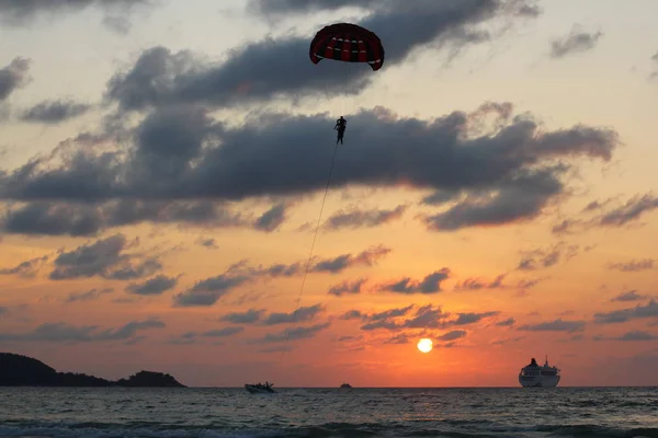 Phuket, Thajsko - 14 března 2017: Parasailing extrémních sportů na pláži Patong na večerní obloze na pozadí — Stock fotografie