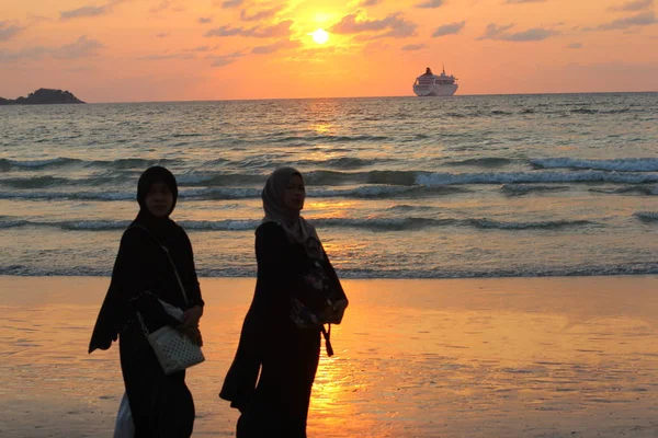 PHUKET, THAILAND - MARCH 14, 2017: Sunset on Patong beach. Crowds of tourists walking and swimming on one of the famous Phuket beach Patong. — Stock Photo, Image