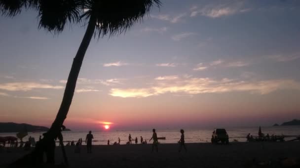 Coucher de soleil sur la plage de Patong. Des foules de touristes marchent et nagent sur l'une des célèbres plages de Phuket Patong. Temps écoulé . — Video