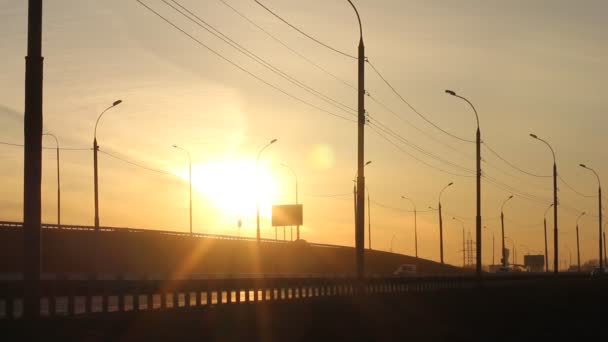Traffic in city highway by sunset. Sundown light with flare. — Stock Video