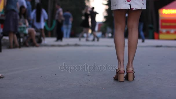 Gambe femminili che ballano salsa. La gente balla nel parco cittadino serale. Movimento salsa sexy. Focus selettivo . — Video Stock