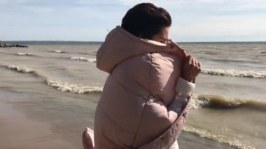 Yalnız Sonbahar plaj ve fırtınalı sarı Deniz'e. Kadın iyi vakit üzerinde deniz kıyısı vardır..