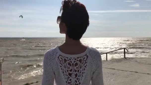 Einsamer Herbststrand und stürmisches gelbes Meer. Frau amüsiert sich am Strand. — Stockvideo