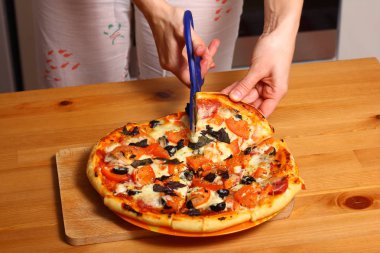 Kadın el pizza dilimlenmiş.