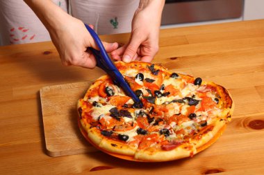 Kadın el pizza dilimlenmiş.