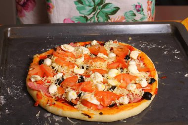 Ev yemeği. Mutfak masasının üzerinde eller pizza yapma.