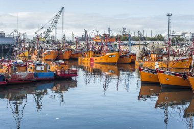 Typical orange fishing boats on the port of the coastal city of Mar del Plata in Buenos Aires province, Argentina clipart