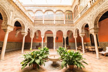 SEVILLE, ES - JULY 27, 2017: The Casa de Salinas in Seville displays its primitive structures of the 16th century with elements from the time of its construction, all aesthetically harmonized. clipart