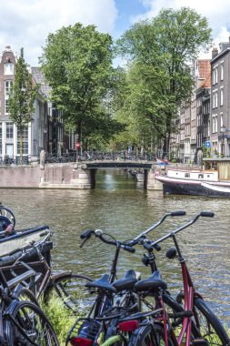 Hollanda 'nın en popüler ulaşım sistemi olan tipik bisikletler Amsterdam banka kanalı üzerinde park halindedir.