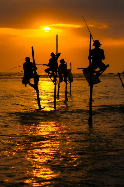 Silhouettes of the traditional stilt fishermen at sunset — Stock Photo, Image