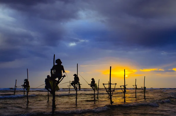 Silhouettes of the traditional stilt fishermen at sunset — Stock Photo, Image