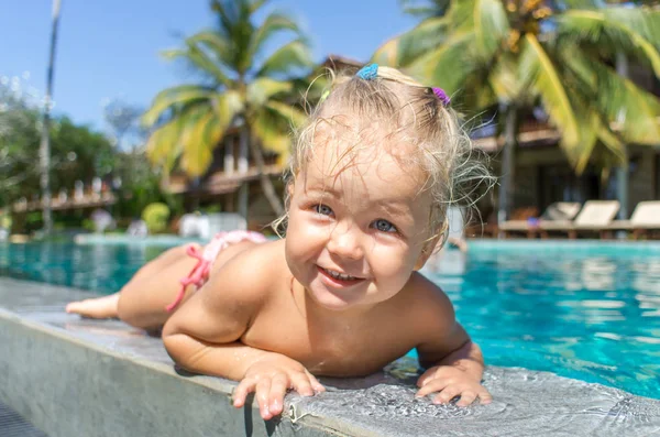 Little girl playing in swimming pool — Stock Photo, Image