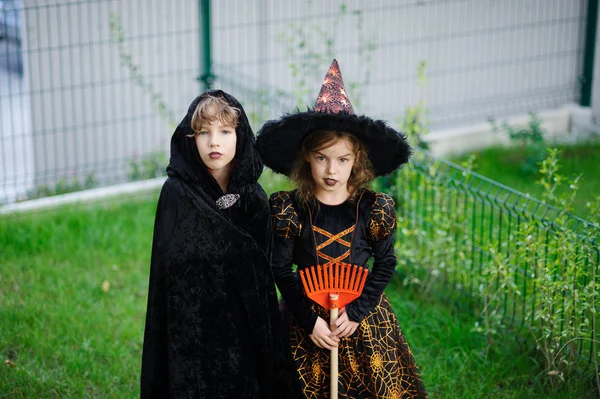 Dvě děti, bratr a sestra, jsou oblečeni v oblecích pro Halloween. — Stock fotografie