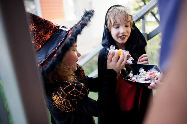 Δύο παιδιά, το αγόρι και το κορίτσι, σκούρα κοστούμια για το Halloween Πάρτε καραμέλες. — Φωτογραφία Αρχείου