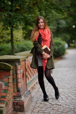 Parktaki köprüde duran genç öğrenci.