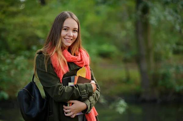 Cheerful student on the background of autumn park. — Stock fotografie