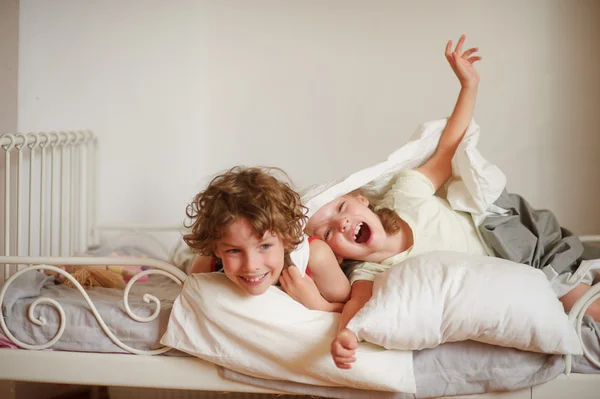 Geniet van twee kinderen, broer en zus, op het bed in de slaapkamer. — Stockfoto
