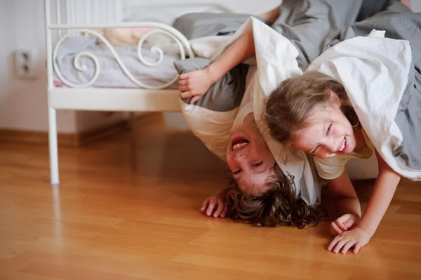 Kinderen, jongen en meisje geniet op het bed in de slaapkamer. — Stockfoto