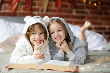 Noel tatili. İki çocuk bir yatak yumuşak pijama lay