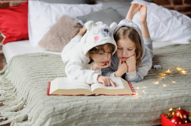 Çocuklar Noel hikaye büyük bir kitap okumak.